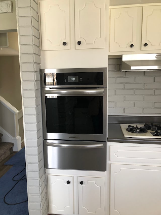 5510 Berkley Dr, Waterford, MI 48327 - kitchen with oven, white gas cooktop, under cabinet range hood, a warming drawer, and white cabinetry