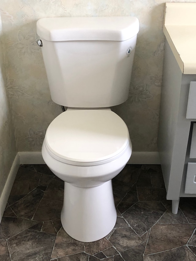 5510 Berkley Dr, Waterford, MI 48327 - bathroom with baseboards, toilet, stone finish flooring, and wallpapered walls