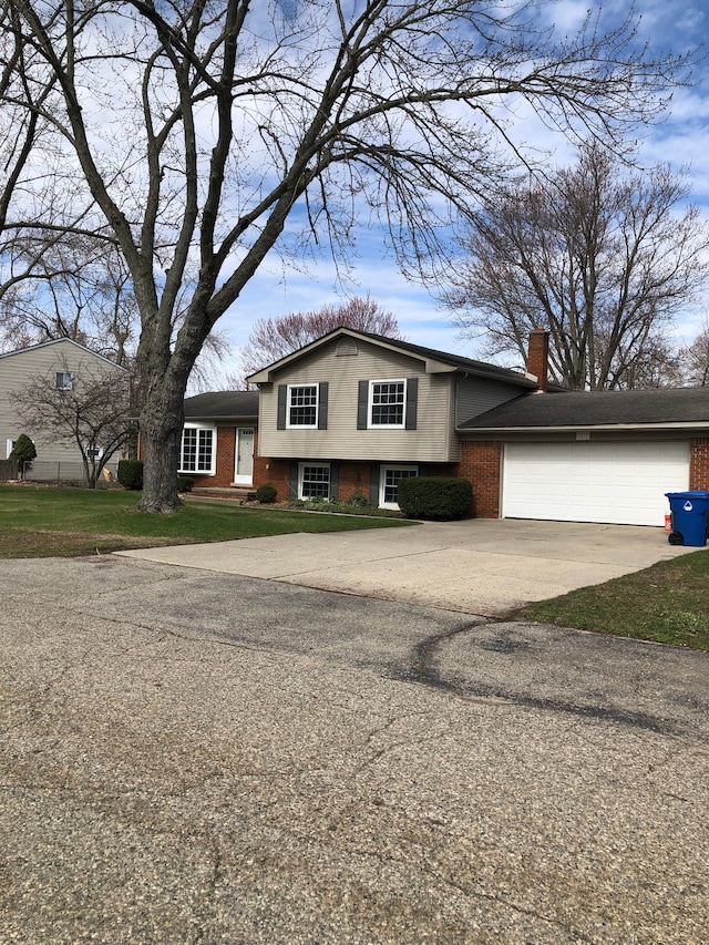 5510 Berkley Dr, Waterford, MI 48327 - tri-level home featuring concrete driveway, an attached garage, a chimney, and brick siding