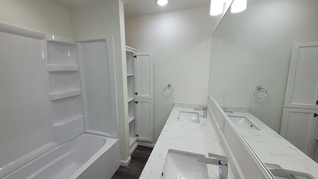 203 E Mill St, Athens, MI 49011 - bathroom featuring double vanity, shower / tub combination, and wood finished floors