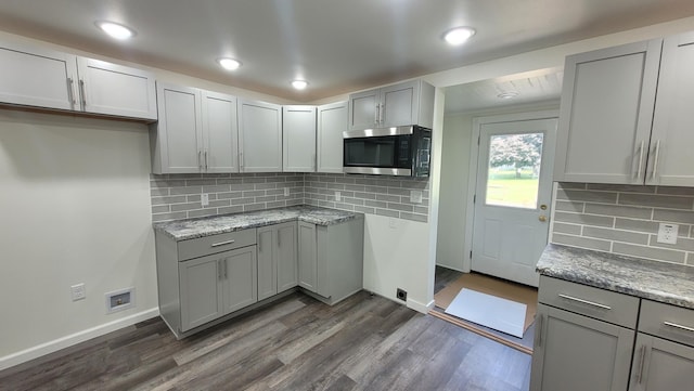 kitchen with tasteful backsplash, gray cabinets, and dark hardwood / wood-style floors