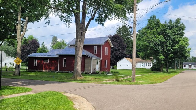 203 E Mill St, Athens, MI 49011 - view of front of property with metal roof and a front lawn