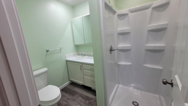 bathroom featuring hardwood / wood-style floors, vanity, toilet, and a shower