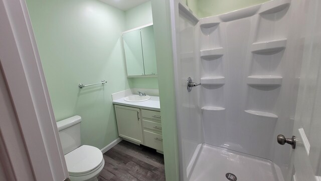 203 E Mill St, Athens, MI 49011 - bathroom featuring toilet, wood finished floors, vanity, a shower stall, and baseboards
