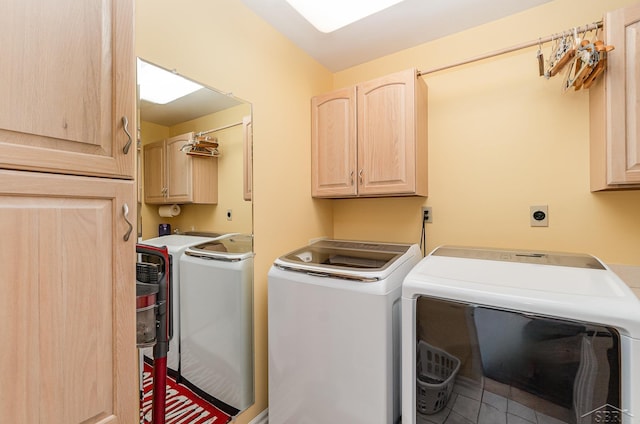 clothes washing area featuring washing machine and dryer and cabinets