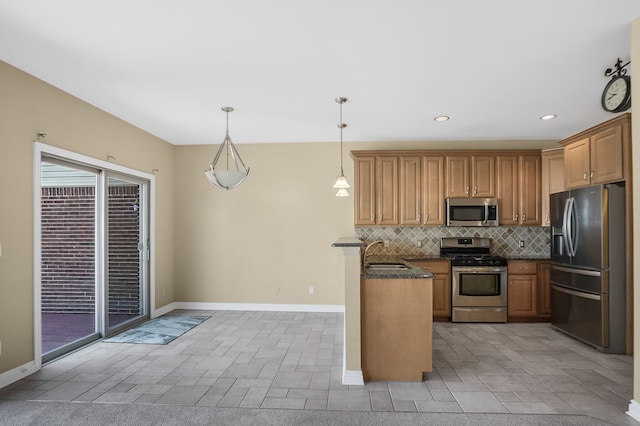 kitchen featuring sink, hanging light fixtures, stainless steel appliances, tasteful backsplash, and dark stone countertops