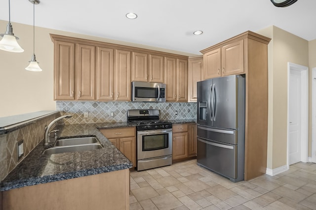 kitchen with pendant lighting, sink, dark stone countertops, tasteful backsplash, and stainless steel appliances