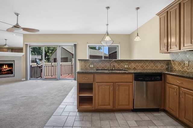 kitchen with stainless steel dishwasher, decorative light fixtures, light carpet, and a wealth of natural light