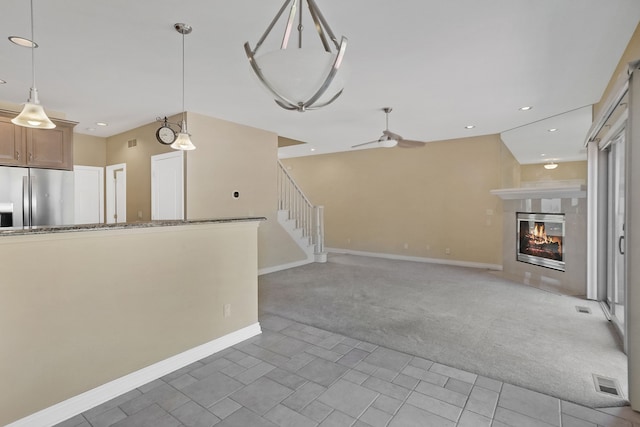 unfurnished living room featuring carpet floors and ceiling fan