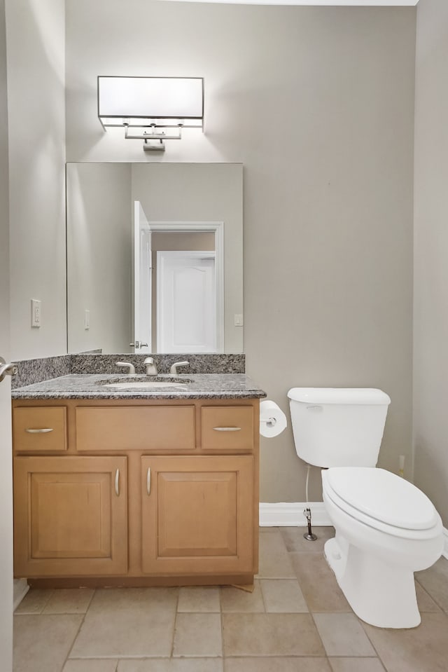 bathroom featuring tile patterned flooring, vanity, and toilet