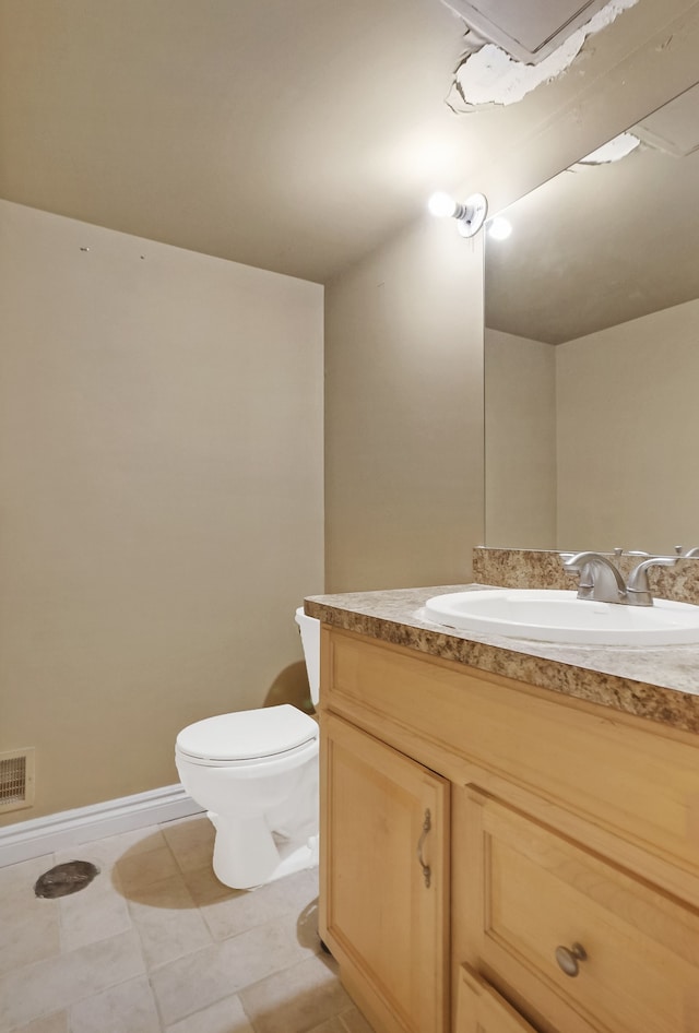 bathroom featuring tile patterned flooring, vanity, and toilet