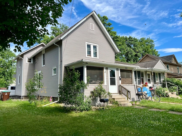 view of front of house with a front lawn and a sunroom