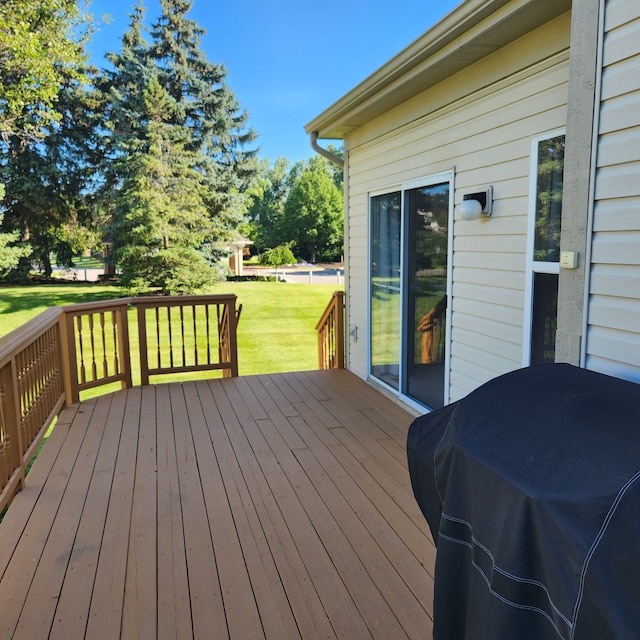 deck featuring area for grilling and a lawn