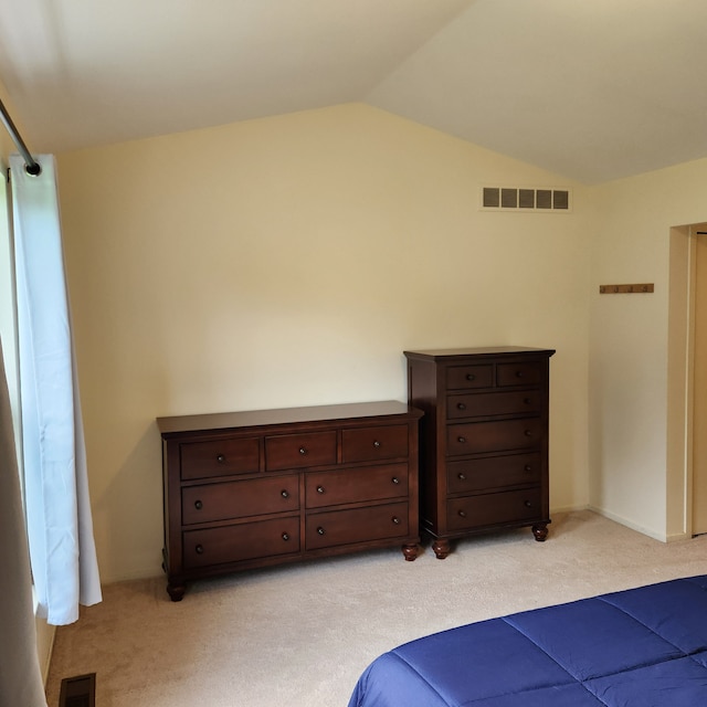 bedroom with light colored carpet and vaulted ceiling