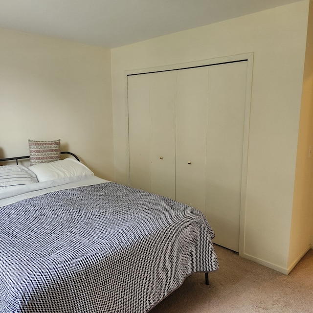 bedroom with light carpet and a closet