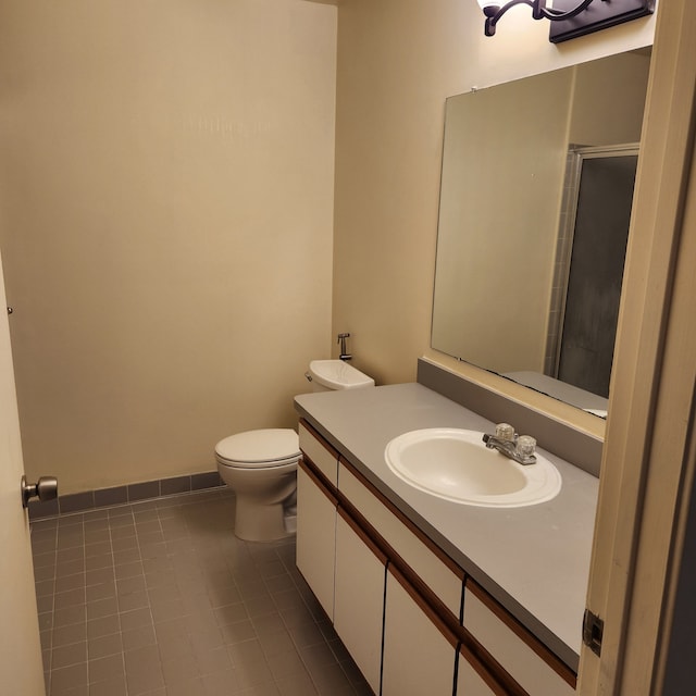 bathroom featuring tile patterned flooring, vanity, a shower with shower door, and toilet