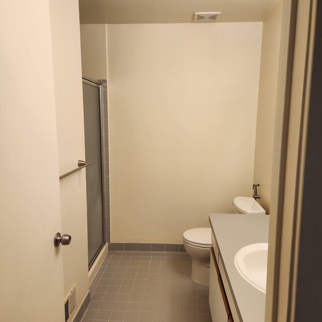 2233 Maplehurst Dr, Walled Lake, MI 48390 - full bathroom featuring vanity, a shower with door, toilet, tile patterned flooring, and baseboards