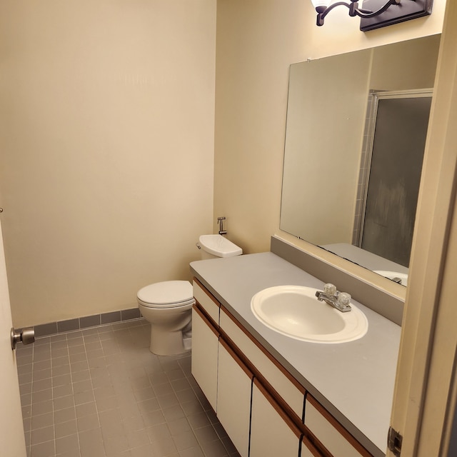 bathroom featuring toilet, vanity, tile patterned floors, and walk in shower