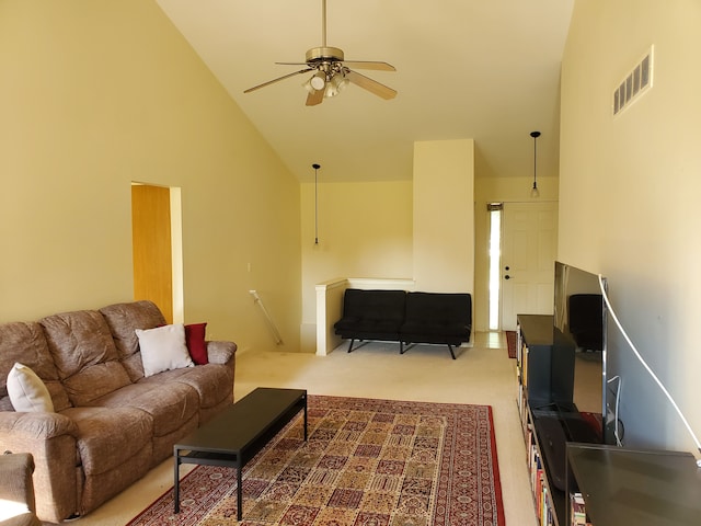 carpeted living room with ceiling fan and high vaulted ceiling