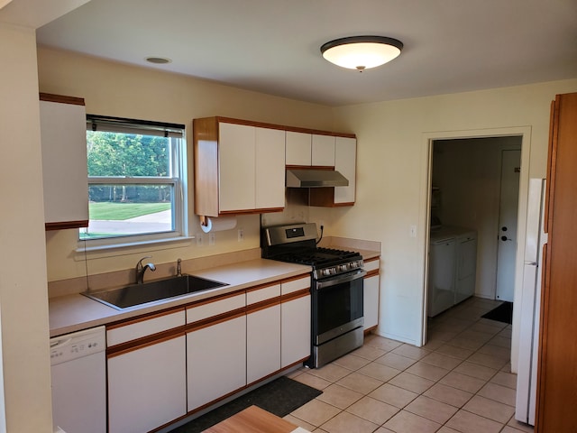 kitchen featuring white cabinetry, sink, white appliances, washer and clothes dryer, and light tile patterned floors