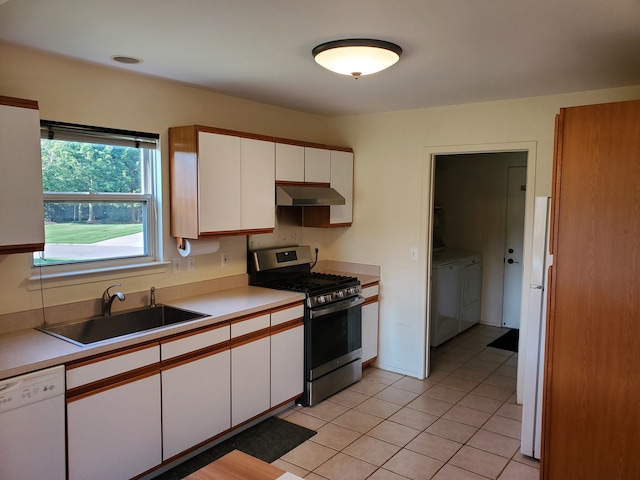 kitchen featuring gas range, white dishwasher, sink, white cabinets, and washing machine and dryer