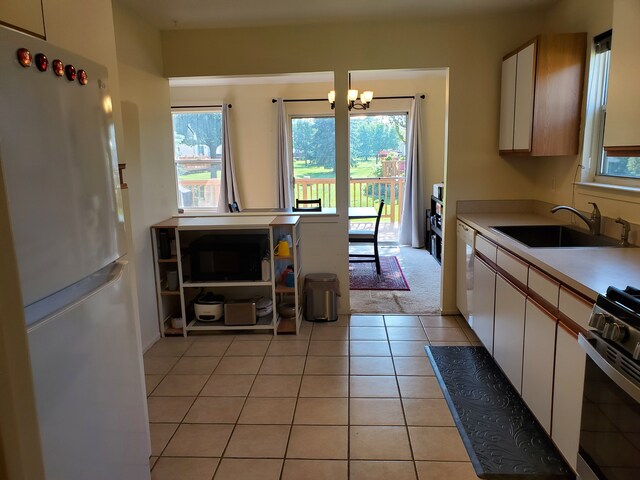 2233 Maplehurst Dr, Walled Lake, MI 48390 - kitchen featuring white appliances, a sink, a chandelier, light countertops, and white cabinets