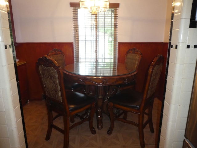 dining space featuring a chandelier and parquet flooring