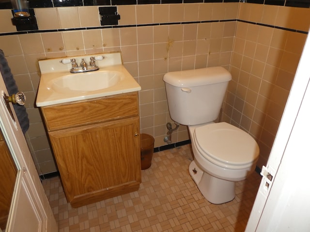 bathroom with tile patterned flooring, vanity, and tile walls