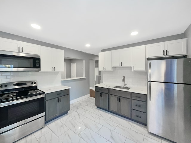 100 E Kalama Ave, Madison Heights, MI 48071 - kitchen with appliances with stainless steel finishes, white cabinetry, a sink, light marble finish floors, and recessed lighting