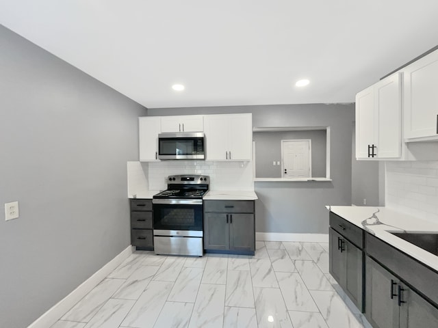 kitchen featuring backsplash, gray cabinetry, white cabinetry, and appliances with stainless steel finishes