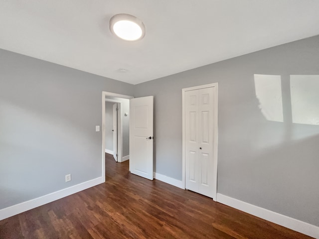 100 E Kalama Ave, Madison Heights, MI 48071 - unfurnished bedroom featuring dark wood-style flooring, baseboards, and a closet