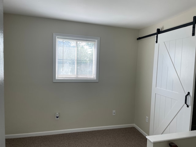 carpeted spare room with a barn door