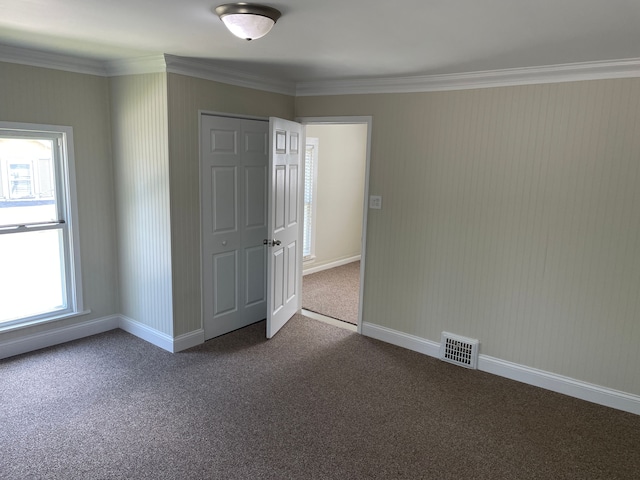 unfurnished bedroom featuring carpet, a closet, and ornamental molding