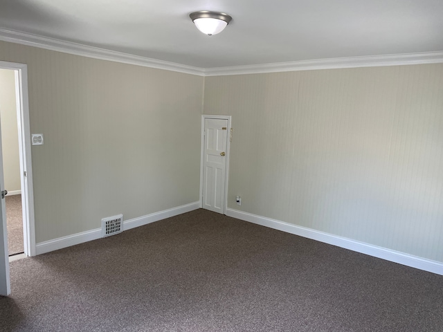 unfurnished room featuring dark colored carpet and crown molding