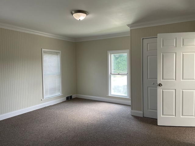 unfurnished room featuring crown molding and dark carpet