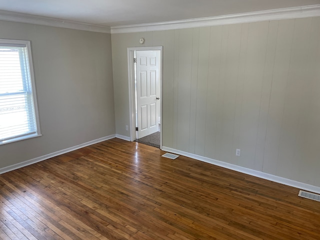 spare room with crown molding and dark wood-type flooring