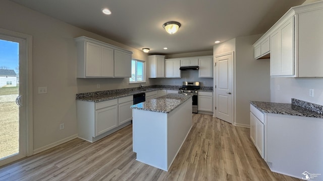 kitchen featuring light hardwood / wood-style flooring, dark stone countertops, stainless steel range, a kitchen island, and white cabinets