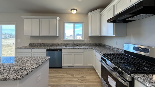 kitchen with sink, white cabinetry, light stone counters, light hardwood / wood-style flooring, and stainless steel appliances