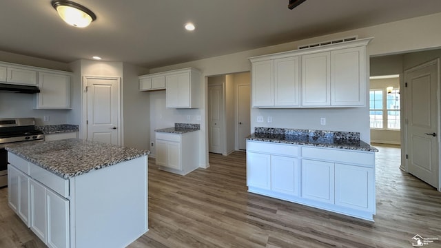 kitchen featuring white cabinetry, stainless steel electric range, and a center island