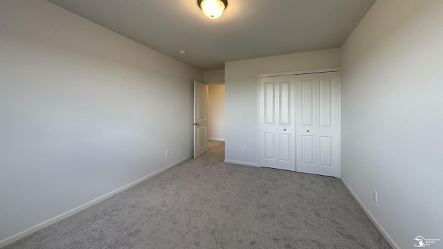 unfurnished bedroom featuring light colored carpet and a closet