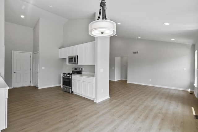 31433 Augusta Dr Unit 75, Romulus, MI 48174 - kitchen featuring appliances with stainless steel finishes, high vaulted ceiling, open floor plan, white cabinetry, and light countertops