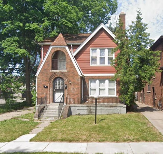 tudor-style house with a front lawn