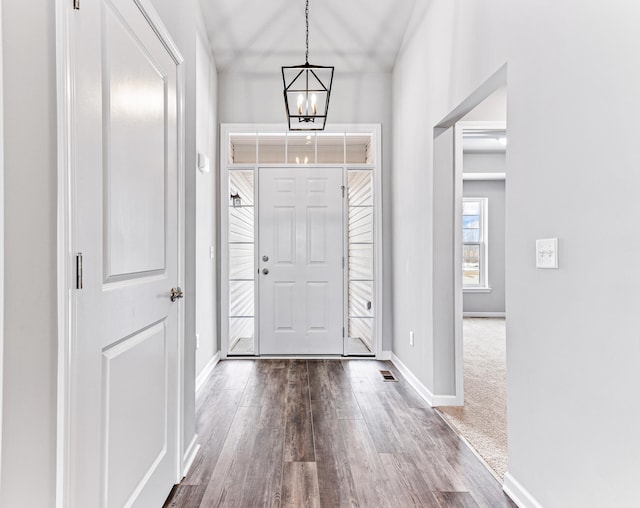 entryway featuring wood-type flooring and an inviting chandelier