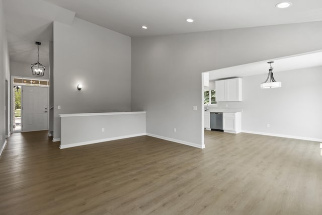 31421 Augusta Dr Unit 76, Romulus, MI 48174 - unfurnished living room featuring plenty of natural light, dark wood-type flooring, recessed lighting, a high ceiling, and a chandelier