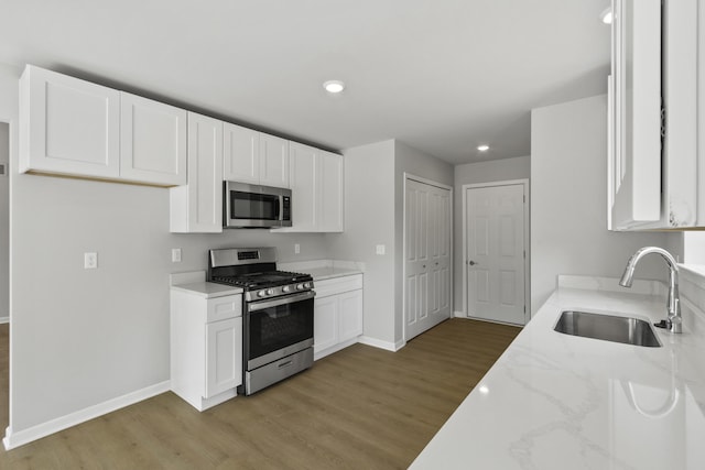 31421 Augusta Dr Unit 76, Romulus, MI 48174 - kitchen featuring appliances with stainless steel finishes, light wood-type flooring, light stone counters, white cabinetry, and recessed lighting
