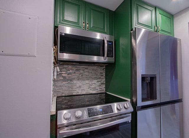 kitchen with tasteful backsplash, green cabinets, and stainless steel appliances