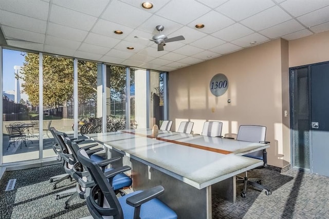 carpeted home office featuring a drop ceiling and ceiling fan