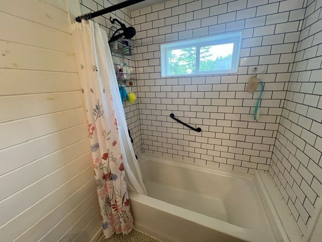 bathroom with shower / bathtub combination with curtain