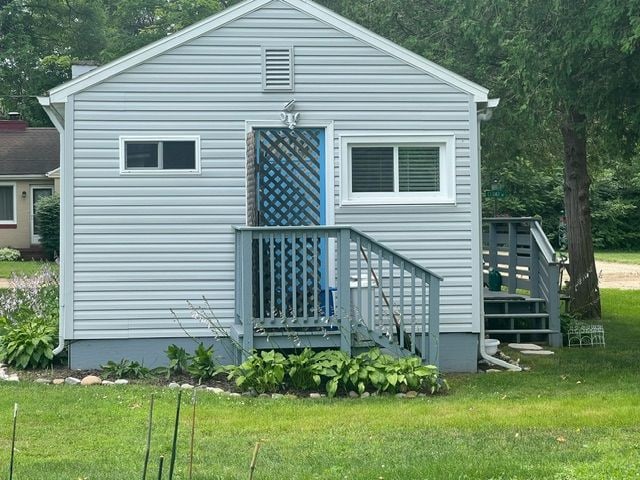 rear view of house featuring a lawn