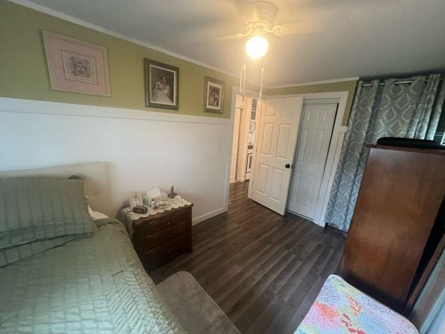 bedroom featuring ceiling fan, dark hardwood / wood-style floors, and ornamental molding